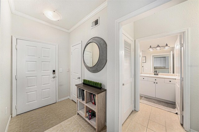 4221 W Spruce St Unit 2104, Tampa, FL 33607 - entryway with crown molding, light tile patterned floors, and a textured ceiling
