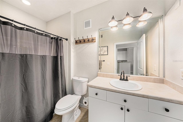 4221 W Spruce St Unit 2104, Tampa, FL 33607 - bathroom featuring toilet, vanity, a textured wall, and curtained shower