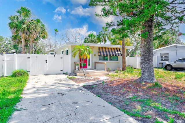 112 11th Ave, Indian Rocks Beach, FL 33785 - view of front of home with a gate, concrete driveway, and stucco siding