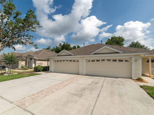 31201 Shaker Cir, Wesley Chapel, FL 33543 - ranch-style house featuring stucco siding, driveway, roof with shingles, and a garage