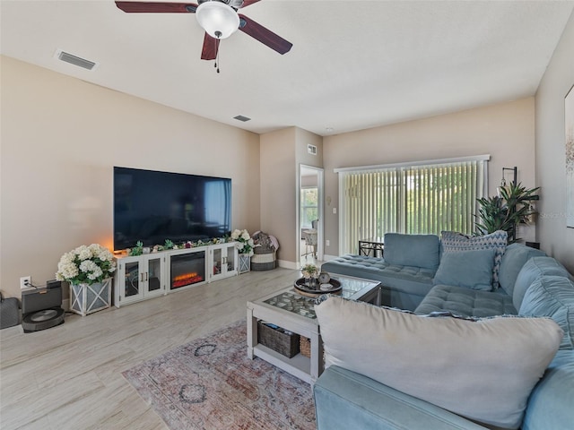 31201 Shaker Cir, Wesley Chapel, FL 33543 - living area with a ceiling fan, wood finished floors, a glass covered fireplace, and baseboards