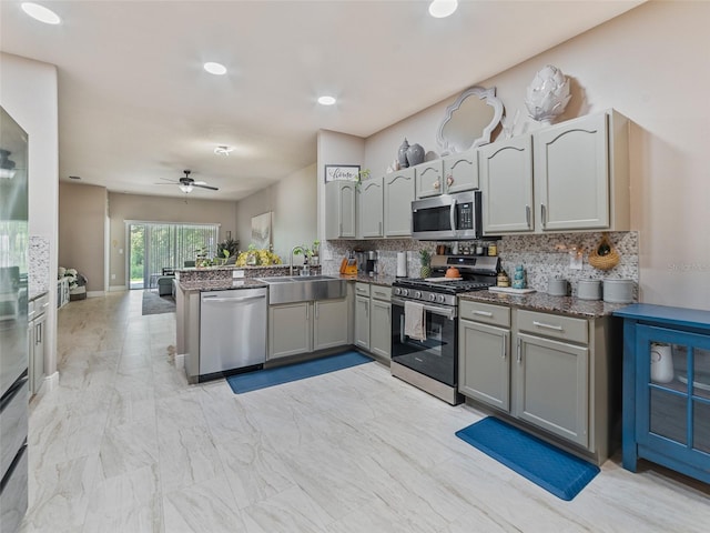 31201 Shaker Cir, Wesley Chapel, FL 33543 - kitchen featuring appliances with stainless steel finishes, a sink, tasteful backsplash, a peninsula, and recessed lighting