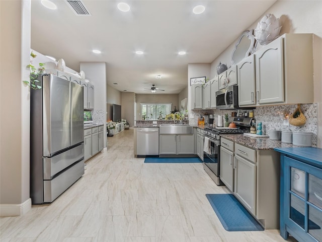 31201 Shaker Cir, Wesley Chapel, FL 33543 - kitchen featuring stainless steel appliances, a peninsula, gray cabinets, backsplash, and recessed lighting
