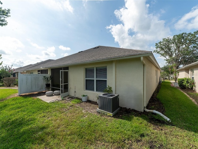 31201 Shaker Cir, Wesley Chapel, FL 33543 - back of property with central AC, stucco siding, a yard, and a shingled roof