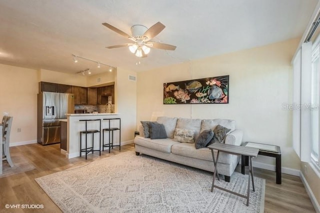 4325 58th Way N Unit 1527, Kenneth City, FL 33709 - living room with light wood-type flooring, ceiling fan, baseboards, and plenty of natural light