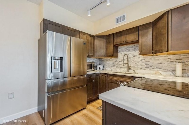 4325 58th Way N Unit 1527, Kenneth City, FL 33709 - kitchen featuring stainless steel appliances, a sink, light countertops, light wood-style flooring, and tasteful backsplash