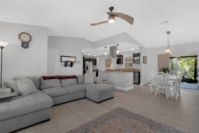 12838 Tallowood Dr, Riverview, FL 33579 - living room featuring vaulted ceiling, a ceiling fan, light wood finished floors, and a chandelier