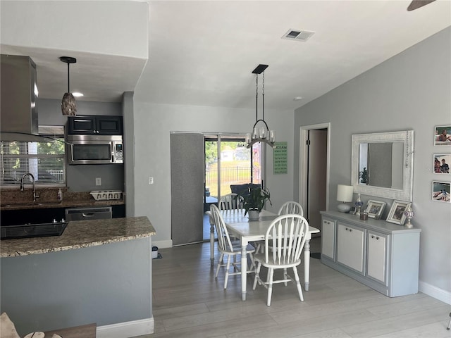 12838 Tallowood Dr, Riverview, FL 33579 - dining area with light wood-type flooring, vaulted ceiling, baseboards, and a chandelier