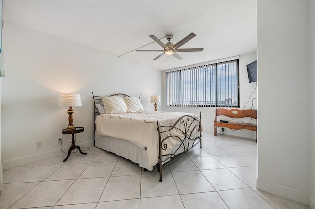 6322 Palma Del Mar Blvd S Unit 1107, Saint Petersburg, FL 33715 - bedroom with baseboards, a ceiling fan, light tile patterned flooring, and a textured ceiling