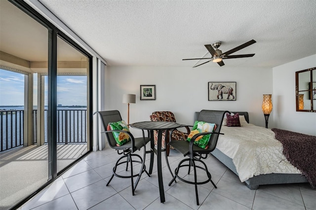 6322 Palma Del Mar Blvd S Unit 1107, Saint Petersburg, FL 33715 - bedroom with access to outside, light tile patterned flooring, a textured ceiling, and ceiling fan