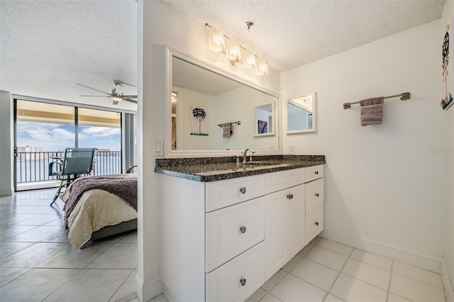 6322 Palma Del Mar Blvd S Unit 1107, Saint Petersburg, FL 33715 - bathroom featuring a textured ceiling, a ceiling fan, vanity, tile patterned flooring, and baseboards
