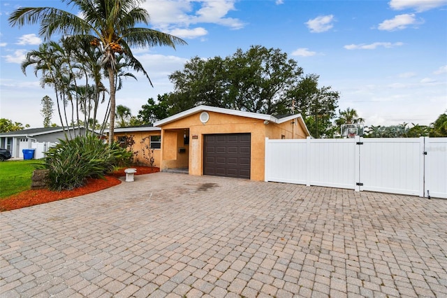 4400 Helena St NE, Saint Petersburg, FL 33703 - single story home with an attached garage, a gate, stucco siding, and driveway