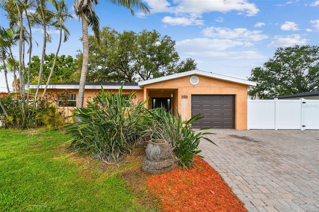 4400 Helena St NE, Saint Petersburg, FL 33703 - view of front of home with a garage, decorative driveway, and stucco siding