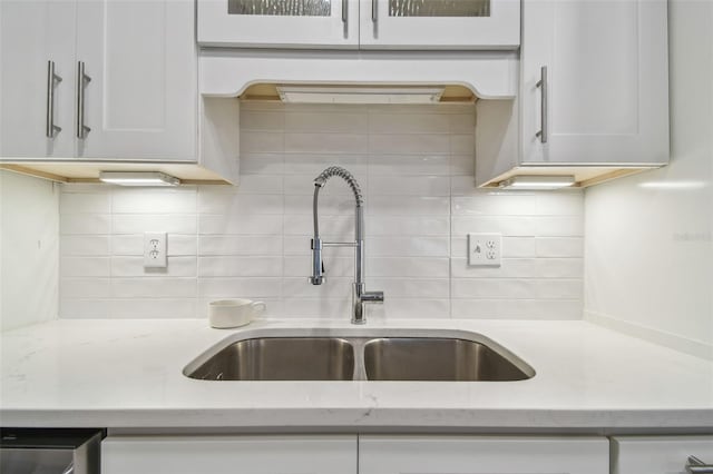 4400 Helena St NE, Saint Petersburg, FL 33703 - kitchen featuring a sink, decorative backsplash, white cabinets, and light stone counters