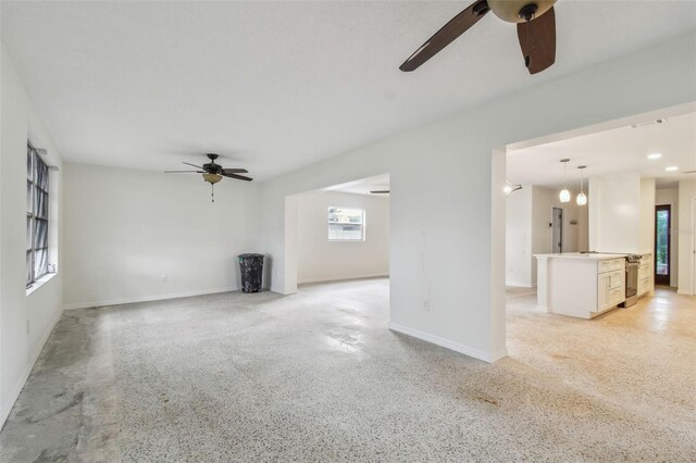 4400 Helena St NE, Saint Petersburg, FL 33703 - unfurnished living room featuring a ceiling fan, baseboards, and dark speckled floor