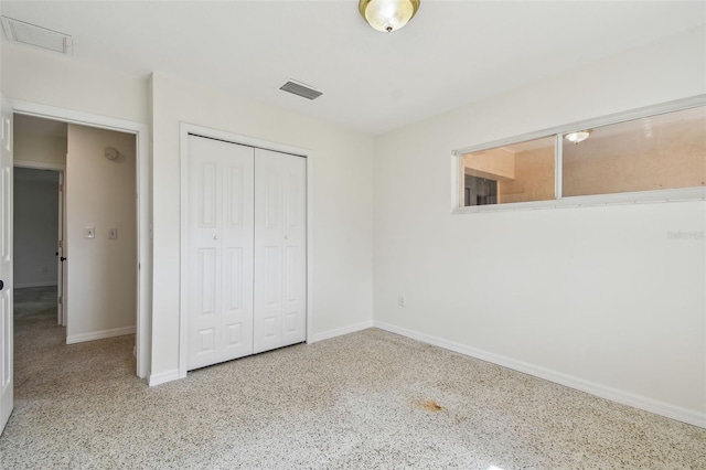 4400 Helena St NE, Saint Petersburg, FL 33703 - unfurnished bedroom with speckled floor, baseboards, and a closet
