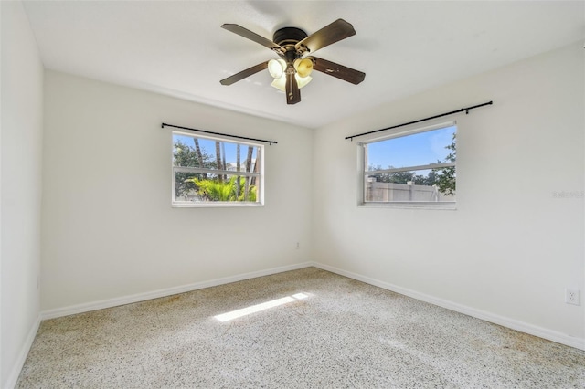 4400 Helena St NE, Saint Petersburg, FL 33703 - unfurnished room featuring healthy amount of natural light, baseboards, a ceiling fan, and speckled floor