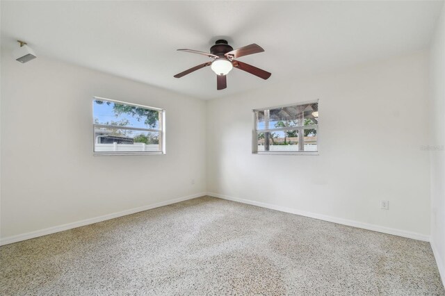4400 Helena St NE, Saint Petersburg, FL 33703 - spare room featuring a ceiling fan, speckle patterned floor, and baseboards