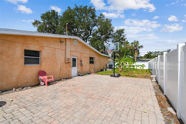 4400 Helena St NE, Saint Petersburg, FL 33703 - rear view of house with a fenced backyard, a patio, central AC unit, and stucco siding