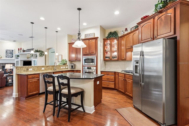 16039 Ternglade Dr, Lithia, FL 33547 - kitchen with stainless steel appliances, a peninsula, brown cabinets, dark wood-style floors, and recessed lighting