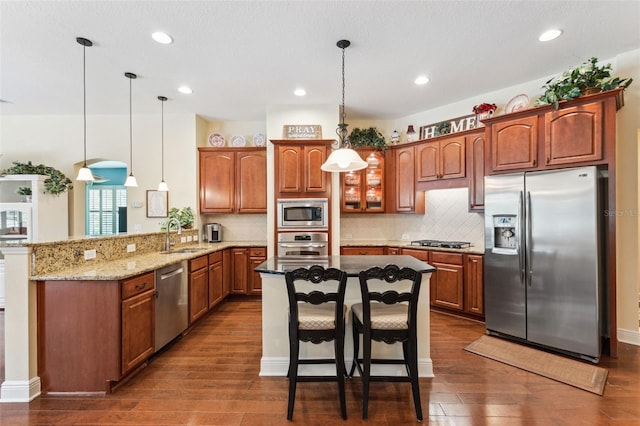 16039 Ternglade Dr, Lithia, FL 33547 - kitchen with appliances with stainless steel finishes, a sink, a kitchen bar, a peninsula, and brown cabinetry