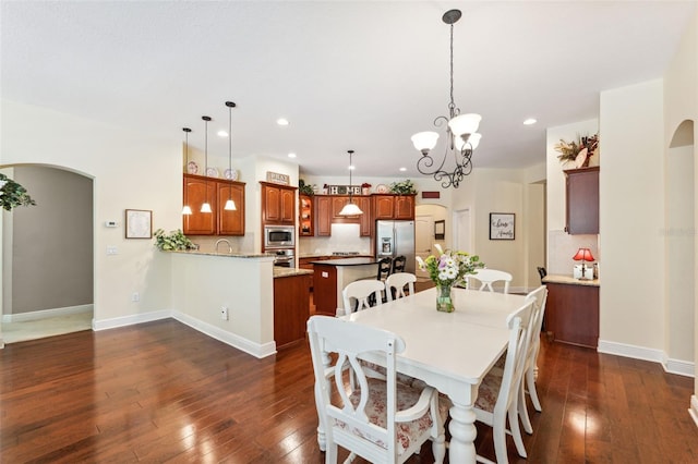 16039 Ternglade Dr, Lithia, FL 33547 - dining room featuring arched walkways, dark wood-style flooring, recessed lighting, and baseboards