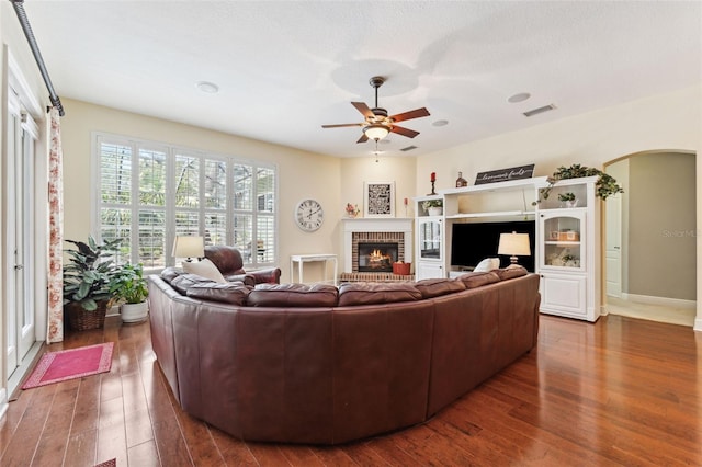 16039 Ternglade Dr, Lithia, FL 33547 - living area featuring arched walkways, hardwood / wood-style floors, a fireplace, and a ceiling fan