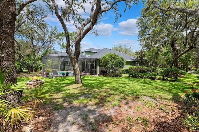 16039 Ternglade Dr, Lithia, FL 33547 - view of grassy yard featuring glass enclosure, a fire pit, and an outdoor pool