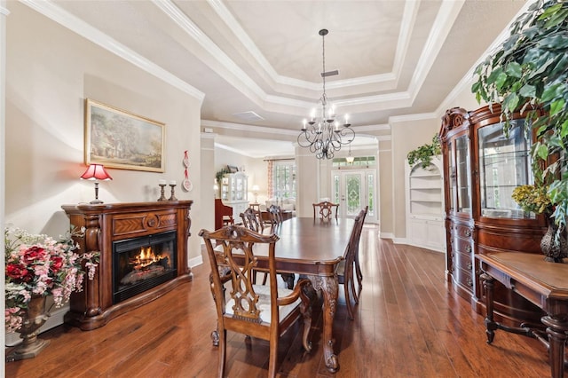 16039 Ternglade Dr, Lithia, FL 33547 - dining area with a raised ceiling, wood-type flooring, a glass covered fireplace, ornamental molding, and a chandelier