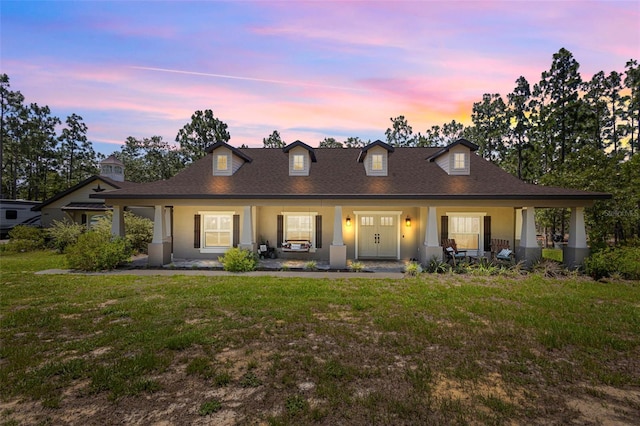 12090 Thames Ave, Weeki Wachee, FL 34614 - view of front of house featuring a porch, a yard, stucco siding, and a shingled roof