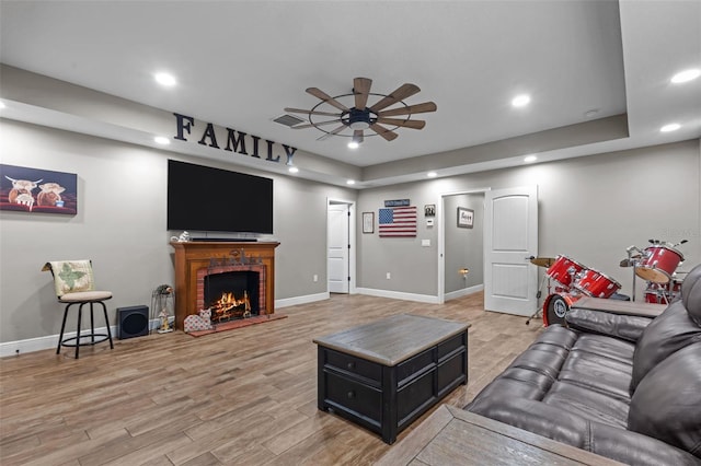 12090 Thames Ave, Weeki Wachee, FL 34614 - living area with ceiling fan, recessed lighting, light wood-style flooring, baseboards, and a fireplace
