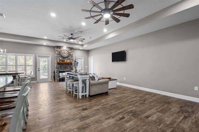 12090 Thames Ave, Weeki Wachee, FL 34614 - living room featuring a ceiling fan, a stone fireplace, dark wood-style floors, recessed lighting, and baseboards
