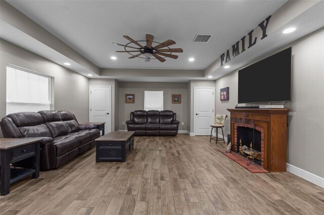 12090 Thames Ave, Weeki Wachee, FL 34614 - living area featuring a ceiling fan, light wood finished floors, a fireplace, baseboards, and recessed lighting