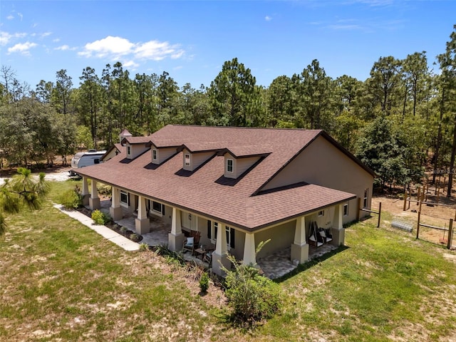 12090 Thames Ave, Weeki Wachee, FL 34614 - view of front of property with a shingled roof, stucco siding, and a porch