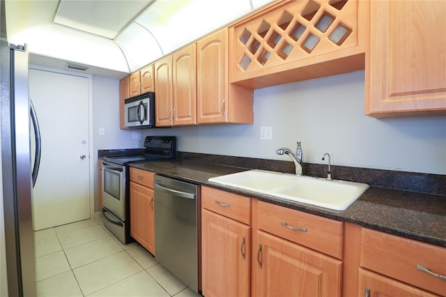 7400 Sun Island Dr S Unit 501, South Pasadena, FL 33707 - kitchen featuring appliances with stainless steel finishes, a sink, light tile patterned flooring, and dark stone counters