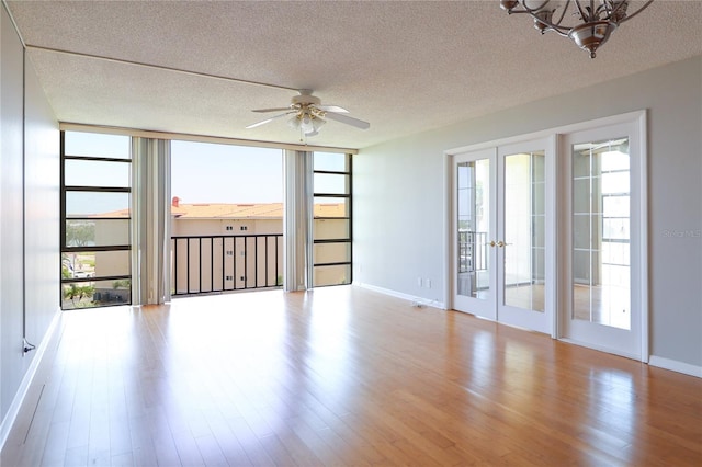 7400 Sun Island Dr S Unit 501, South Pasadena, FL 33707 - unfurnished room with french doors, a textured ceiling, wood finished floors, a ceiling fan, and baseboards