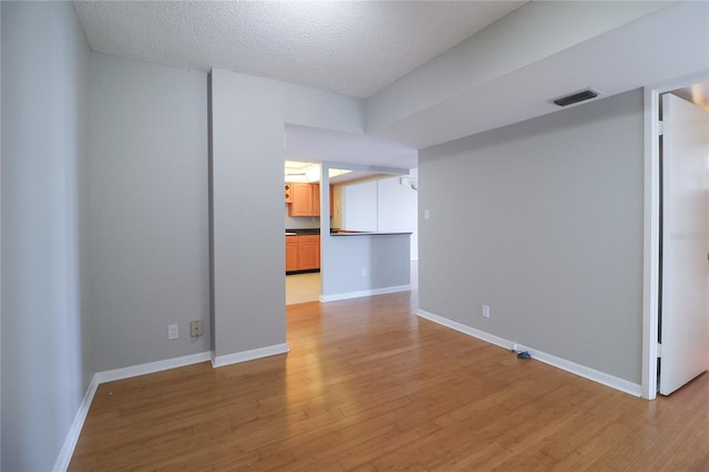 7400 Sun Island Dr S Unit 501, South Pasadena, FL 33707 - unfurnished room with light wood-type flooring, a textured ceiling, and baseboards