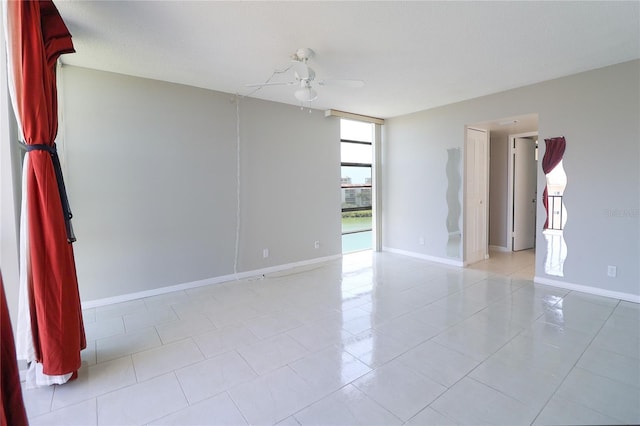 7400 Sun Island Dr S Unit 501, South Pasadena, FL 33707 - spare room with a ceiling fan, light tile patterned floors, baseboards, and expansive windows