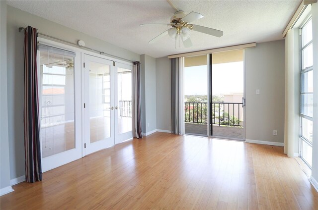 7400 Sun Island Dr S Unit 501, South Pasadena, FL 33707 - unfurnished room featuring french doors, a textured ceiling, light wood-style floors, a ceiling fan, and healthy amount of natural light