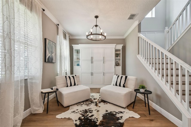 17589 Cruiser Bnd, Land O Lakes, FL 34638 - foyer featuring a chandelier, ornamental molding, wood finished floors, baseboards, and stairs
