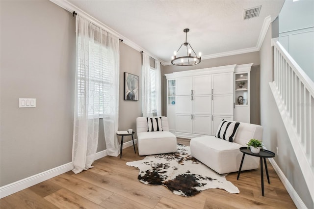 17589 Cruiser Bnd, Land O Lakes, FL 34638 - sitting room with crown molding, baseboards, a chandelier, light wood-style flooring, and stairs