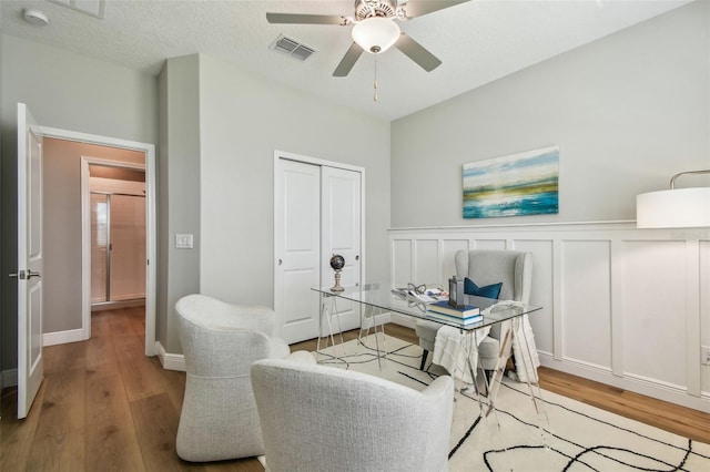 17589 Cruiser Bnd, Land O Lakes, FL 34638 - home office with wood finished floors, ceiling fan, wainscoting, and a decorative wall