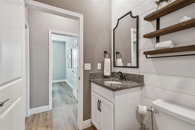 17589 Cruiser Bnd, Land O Lakes, FL 34638 - half bathroom featuring toilet, wood finished floors, vanity, and baseboards