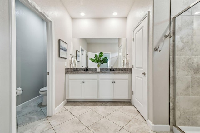 17589 Cruiser Bnd, Land O Lakes, FL 34638 - full bath featuring double vanity, a stall shower, toilet, tile patterned floors, and baseboards