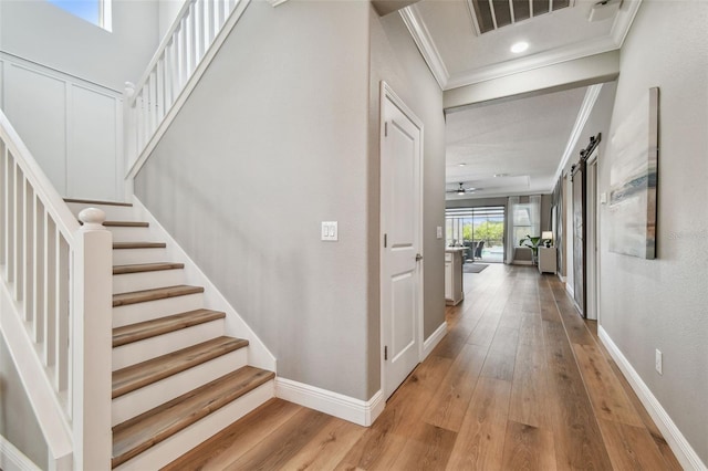 17589 Cruiser Bnd, Land O Lakes, FL 34638 - stairs featuring crown molding, hardwood / wood-style floors, and baseboards