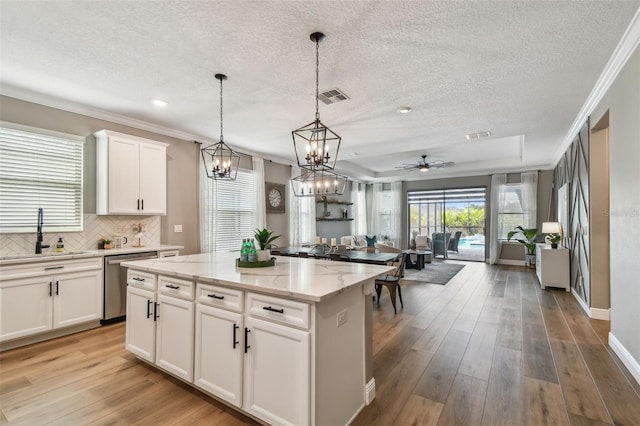 17589 Cruiser Bnd, Land O Lakes, FL 34638 - kitchen featuring stainless steel dishwasher, a sink, a textured ceiling, a center island, and open floor plan