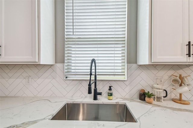 17589 Cruiser Bnd, Land O Lakes, FL 34638 - kitchen view of a sink, white cabinetry, and tasteful backsplash