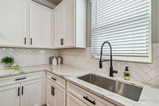 17589 Cruiser Bnd, Land O Lakes, FL 34638 - kitchen featuring a sink, white cabinetry, decorative backsplash, and light stone counters