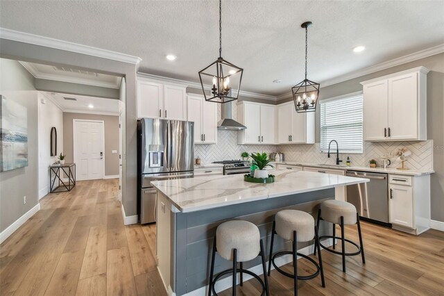 17589 Cruiser Bnd, Land O Lakes, FL 34638 - kitchen featuring appliances with stainless steel finishes, wall chimney exhaust hood, a sink, a chandelier, and ornamental molding