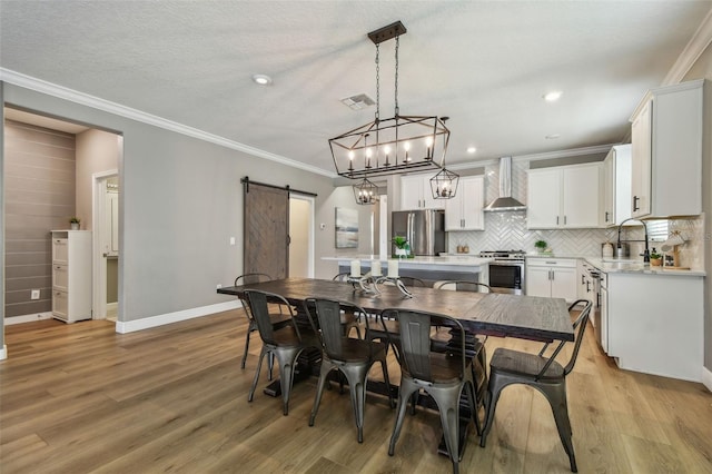 17589 Cruiser Bnd, Land O Lakes, FL 34638 - dining space with a barn door, baseboards, light wood-style flooring, ornamental molding, and recessed lighting
